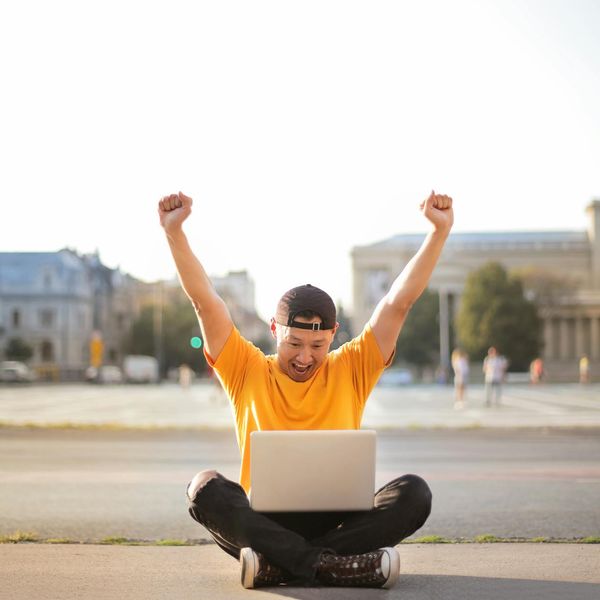 A man smiling, looking energetic and full of vitality outdoors.